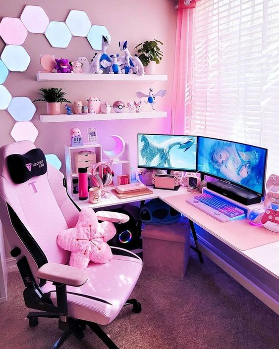 a pink gaming desk setup with a corner desk, a colorful keyboard, shelves with decor, neon hexagon lights, a pink chair and a flower pillow