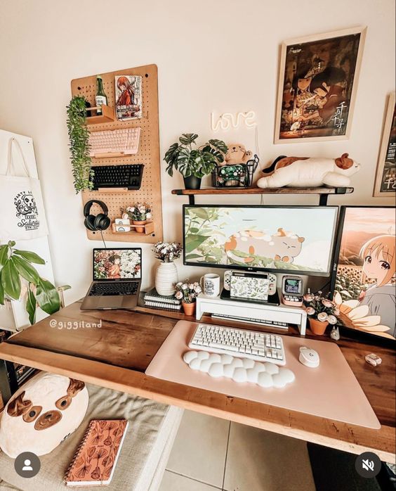 a pretty gaming desk setup with a memo board and some decor, potted greenery and toys, some lovely small stuff and decor