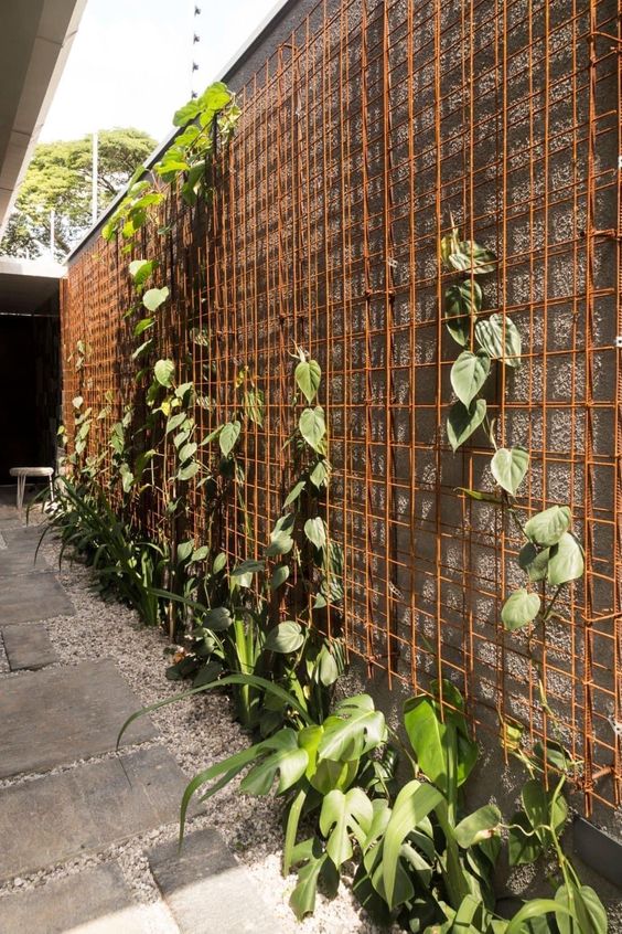 a privacy fence paired with an orange trellis and greenery is a lovely way to make your fence look lively and fresh