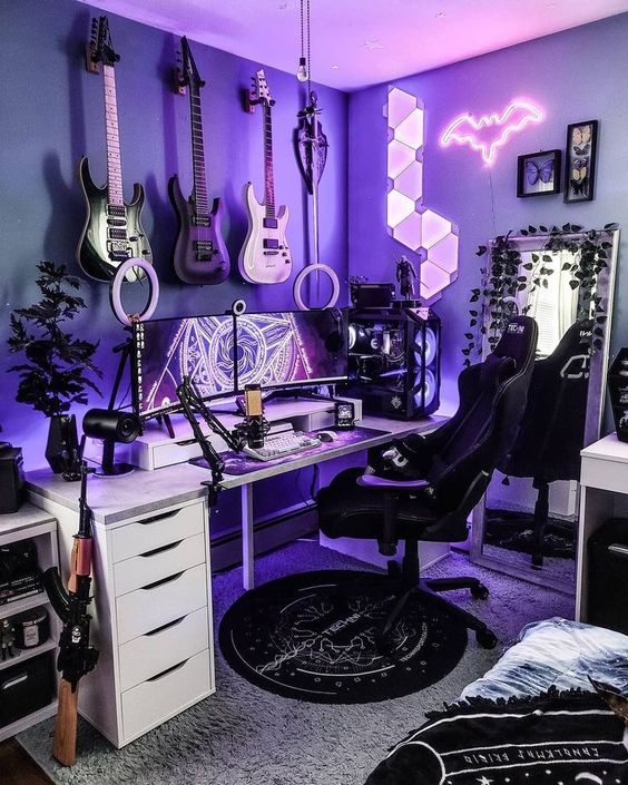 a purple gaming setup with lights and a bat light, a desk and a chair, some decor, a mirror, wall art, guitars on the wall