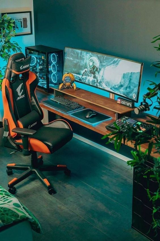 A simple modern gaming nook with a desk, a PC, a yellow and black chair, potted plants and some stylish game inspired decor