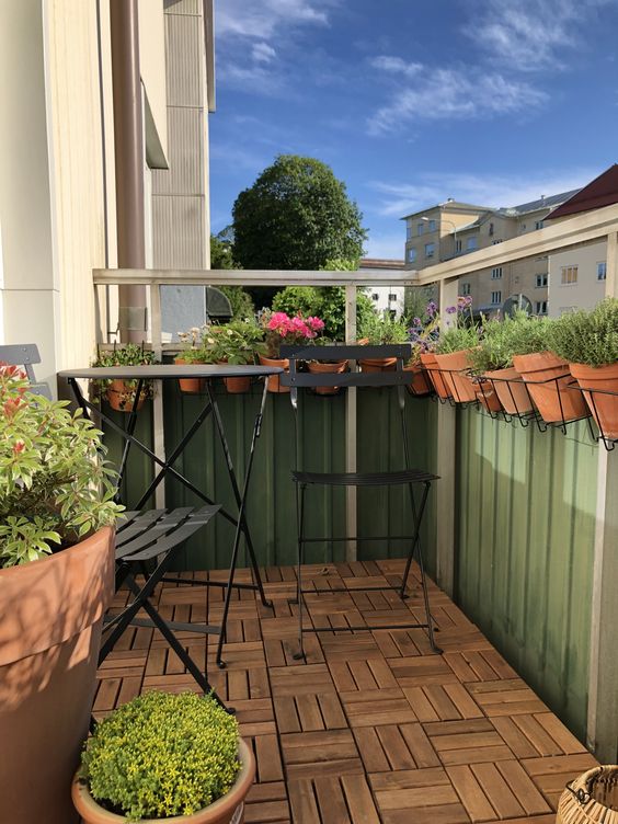 a small and cool balcony with wire plant holders hanging on the railings is a smartly organized space where you can grow some herbs and beggies