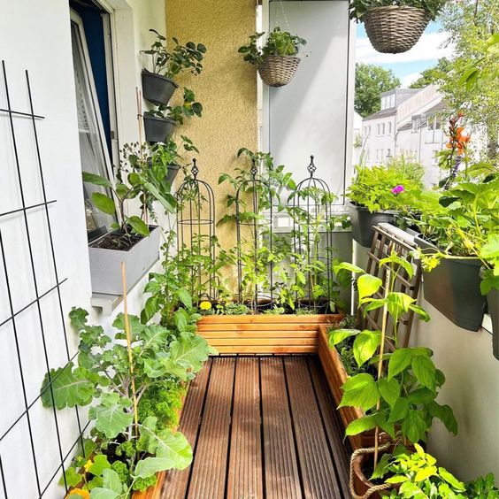 a small balcony with railing planters and planters on the floor, with baskets with herbs is a lovely and cool space