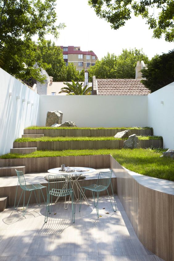 a small multi-level outdoor space with a green lawn, some simple furniture is a cool idea if you don't have much space
