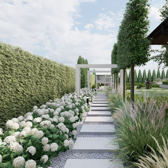 a stunning modern garden with a living wall, lots of blooms and stylish grasses, large pavements and arches is wow