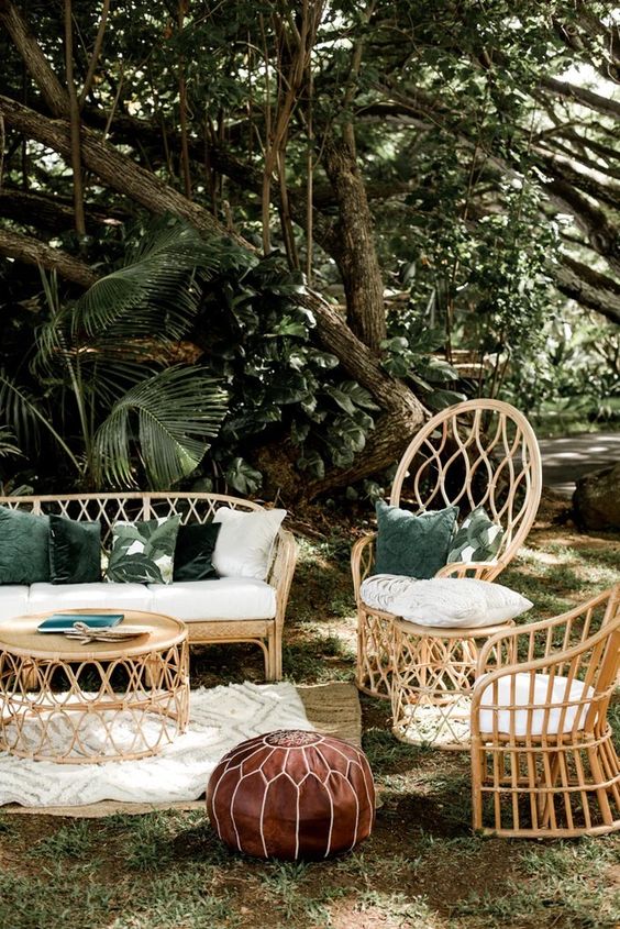 a tropical outdoor area with rattan furniture, boho rugs and a leather pouf is a cool solution