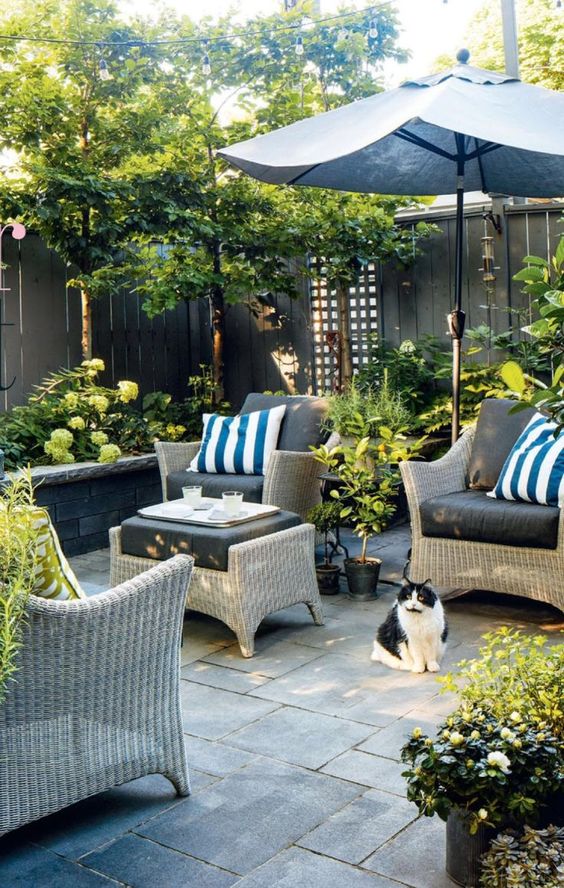 a welcoming terrace with tiles, wicker furniture, printed textiles, greenery and blooms is very stylish
