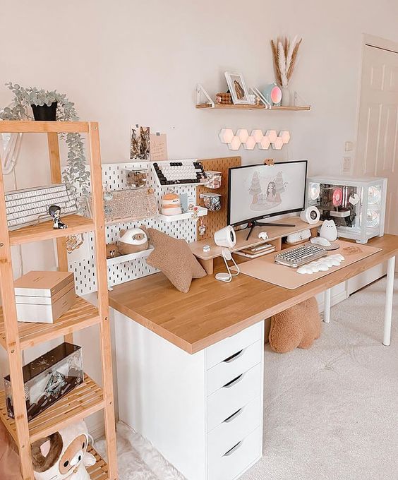 a white Scandi gaming desk setup with a desk, a shelving unit, a memo board with shelves, some lamps and simple decor