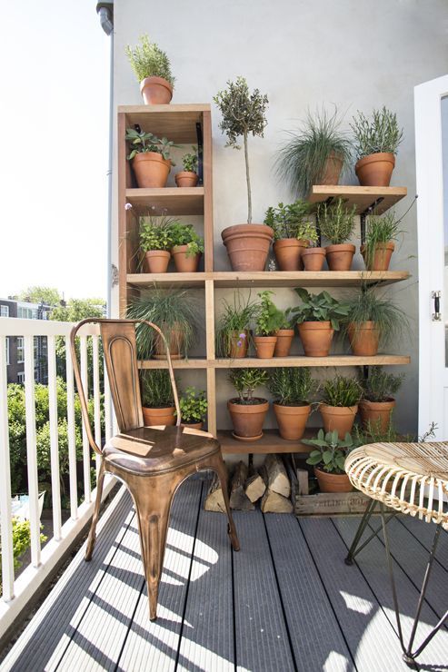 a wooden planter holder or shelving unit with some potted plants is a cool idea for a balcony, you can grow whatever you like there