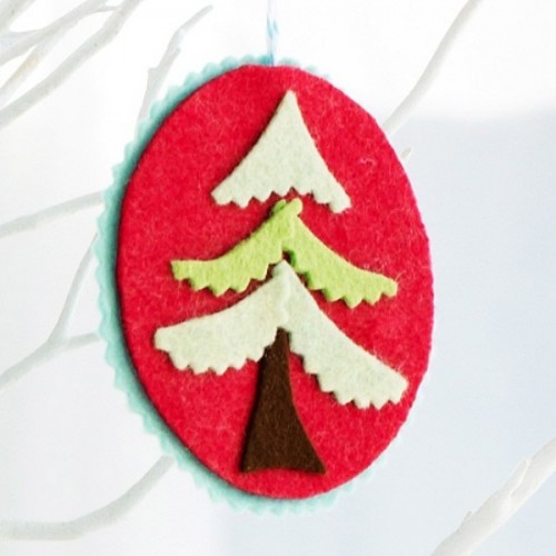 A red felt Christmas ornament with a tree of felt is a non typical and cute idea of a decoration that you can make yourself