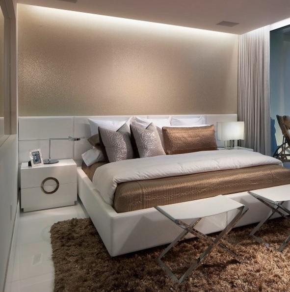 Neutrals, tan and brown decor, built in lights and touches of metal make up the small bedroom larger and very luxurious