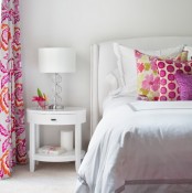 a small bedroom decorated only in white and with just a splash of bright colors – pillows and curtains – looks bold and cool