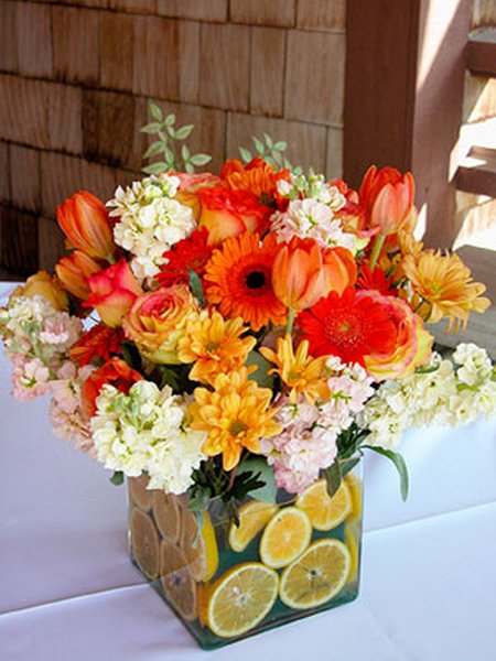 A seasonal arrangement of ornamental flowers in vibrant colors takes center stage on the dinner table.