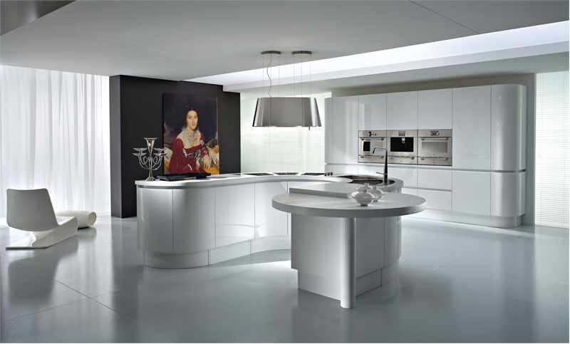 An all white kitchen with curved furniture, a large curved storage unit with built in appliances and a large statement artwork