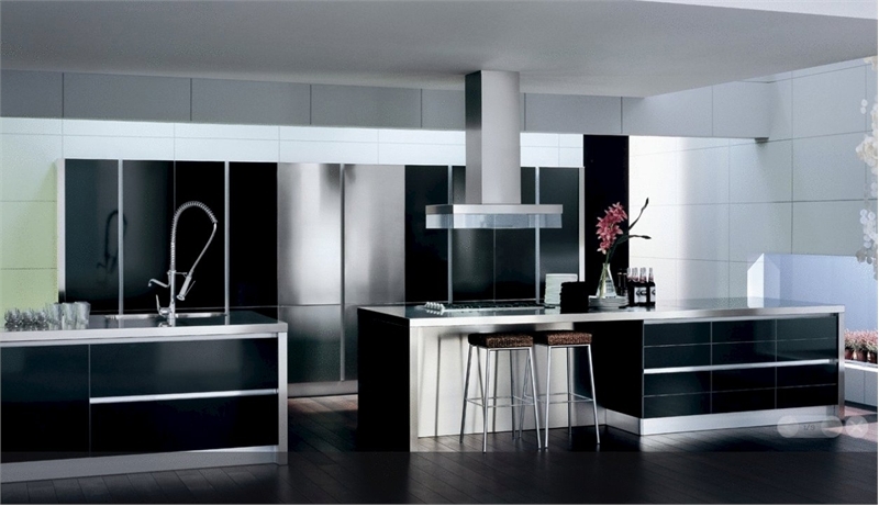 A black, white and silver modern kitchen with built in appliances and storage units, with white countertops and a suspended hood