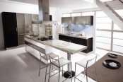 a contemporary kitchen with black lower cabinets and a large storage unit with black and sheer parts, with a table-style kitchen island and chairs and stools