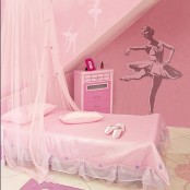 a pink ballerina-inspired kid’s room with a canopy bed and a ballet dancer art on the wall