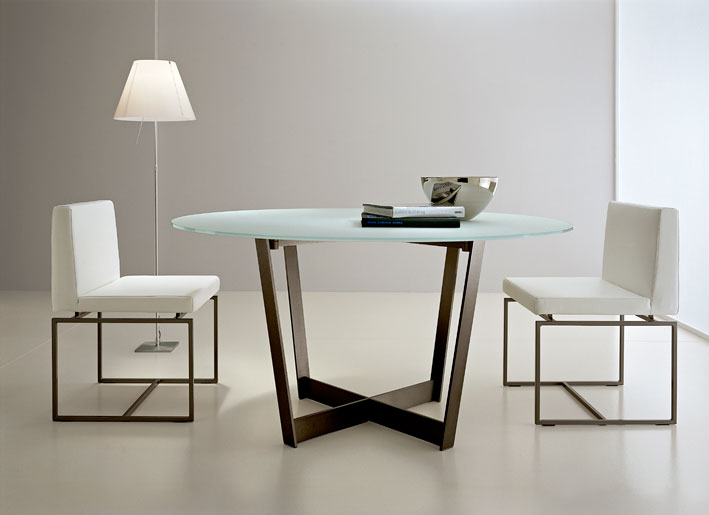 A classic dining table with a blue round glass tabletop and brown legs that create a criss cross is a perfect idea for a modern dining room