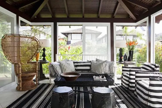 A sunroom for gatherings with lots of black and white stripes.