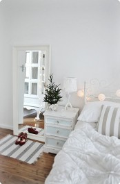 a mini Christmas tree, lights and stars for a neutral bedroom that feels like holidays