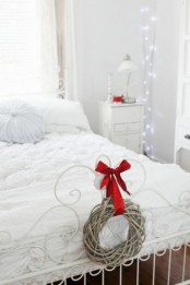 white lights on branches, a mini vine wreath with a red bow bring a holiday feel to the space