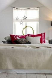 stars over the bed and red Christmas pillows immediately bring a holiday feel to the space