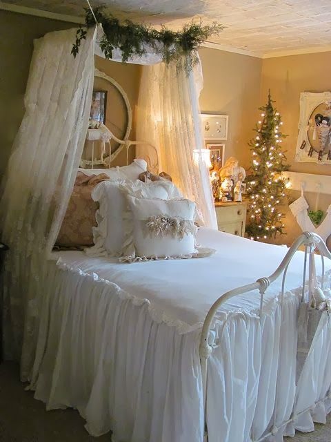 A neutral vintage inspired bedroom with evergreens and lights, a Christmas tree and some art
