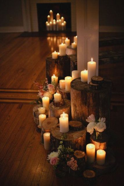 tree stumps as candle holders, blooms in vases for a chic rustic fireplace with a touch of romance