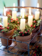 a wire tray with small planters with evergreens, red berries and candles is a lovely realxed rustic Christmas decoration