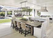 a modern white kitchen and a modern farmhouse dining zone opened to outdoors and the garden with a garage door