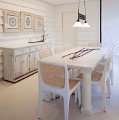 a whitewashed buffet, a whitewashed table and chairs with rattan seats and backs create a mood in this lovely shabby chic space