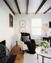 dark wooden beams, a fireplace and white brick walls give a more rustic and less formal look to the space
