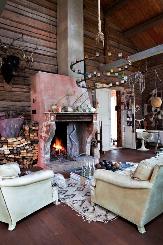 an eclectic living room with cabin touches - much wood, a large fireplace and a firewood storage