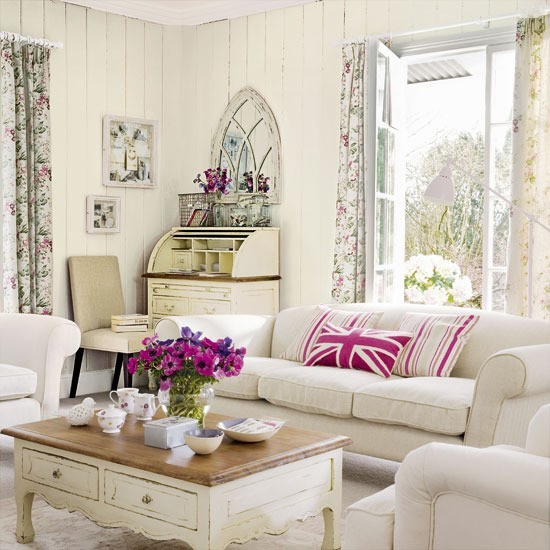 a neutral rustic living room with shiplap on the walls, vintage furniture and floral curtains
