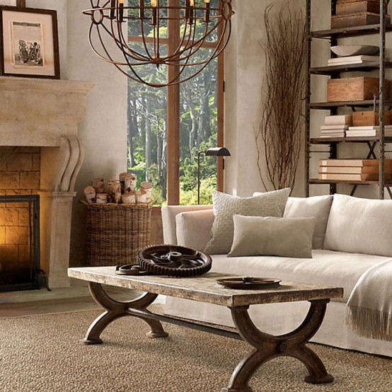 a large fireplace, rustic wooden furnniture and an orb chandelier plus firewood in a basket