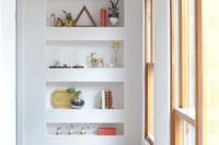 a wall with a series of sleek niche shelves is a cool solution to store and display things in a modern way