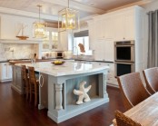 a fresh take on a classic beach kitchen with white shaker style cabinets, white tiles, a light blue kitchen island and some beach decor – a starfish and a boat