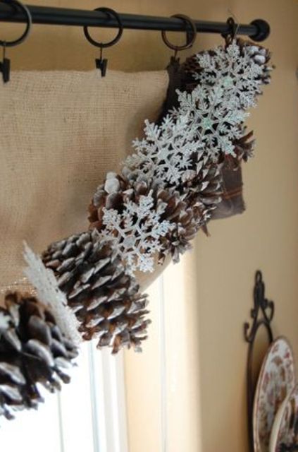 a beautiful pinecone and snowflake garland is a cool decor idea for the holidays and for Christmas, it looks cute and lovely