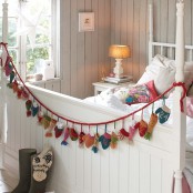 a small and colorful knit garland of beanies and mittens can be DIYed, it’s an out of the box idea and looks cute