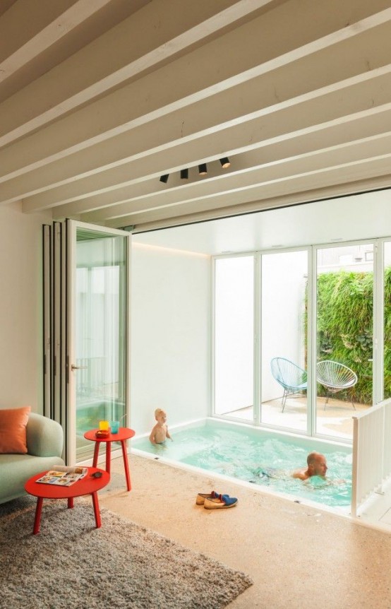 a small indoor pool in a living room that is connected to the private courtyard with a glazed wall is a great idea