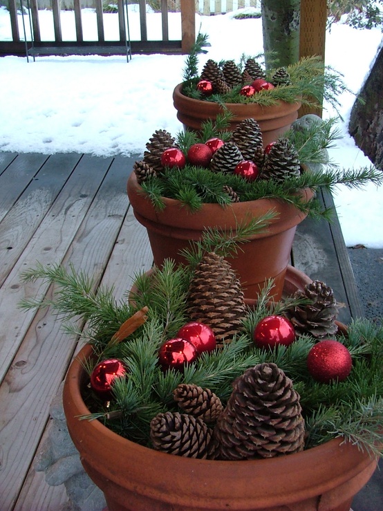 Stuff evergreen trimmings into terracot planters, add some ornaments and pinecones to them. Next, line them up on your porch to add some greenery to it.