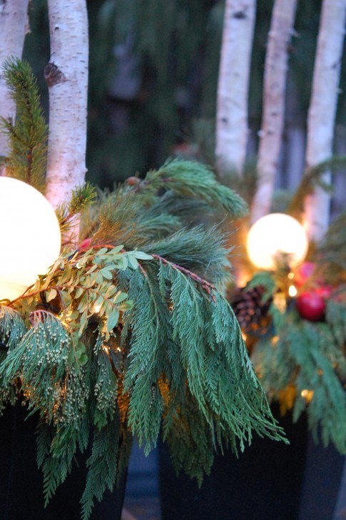 Cover garden lights with pine trimmings to set a celebratory tone for the whole backyard.