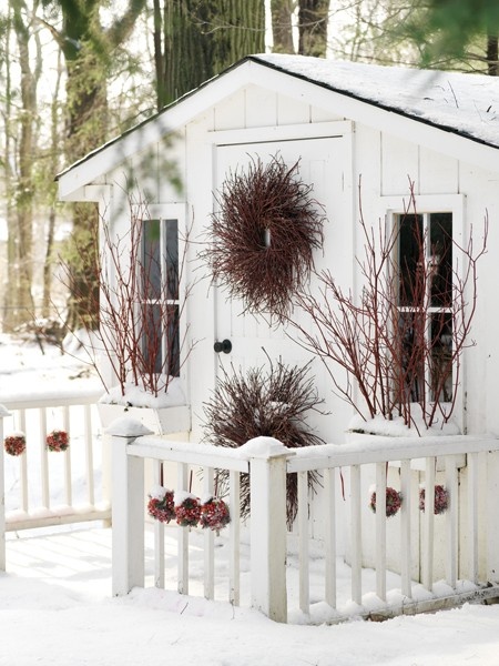 Red ornaments strung along the charming white fence up the festive mood. Besides, two wreaths give this  entryway a fairy-tale feel.