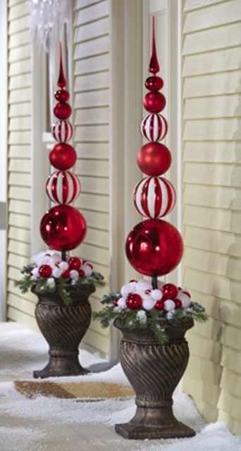 Two urns, filled to the brim with pine twigs and faux topiaries made of Christmas ornaments are perfect for dramatic holiday greeting at the front door.