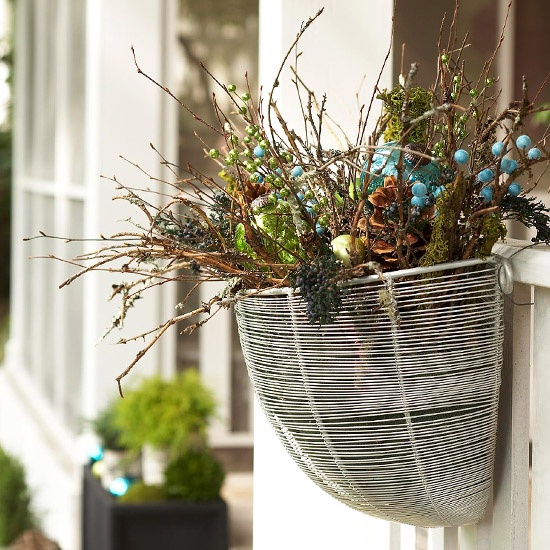 Instead of a wreath, try hanging a basket filled with greens, twigs, pinecones or ornaments.