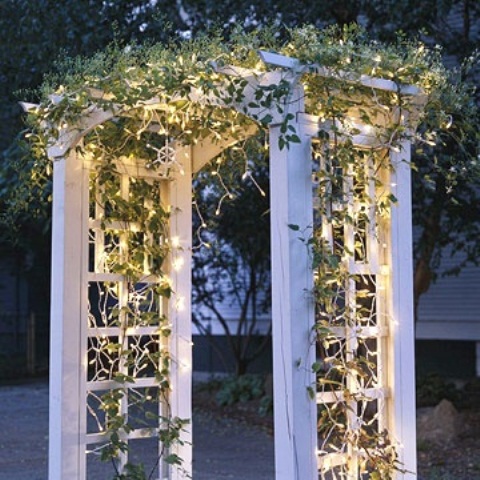 Outlining a garden arch in garland with Christmas lights is an elegant and simple way to create a seasonal focal point in your backyard.