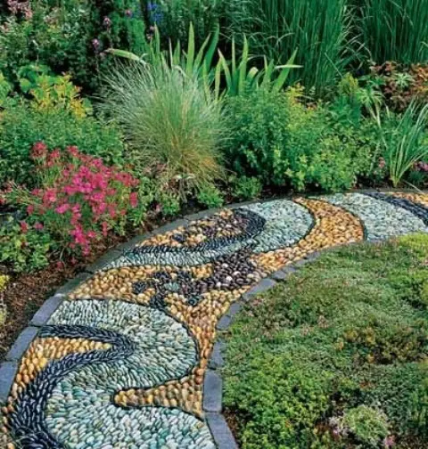 a bright pebble path in yellow, mint green and black with a catchy pattern and dark brick borders
