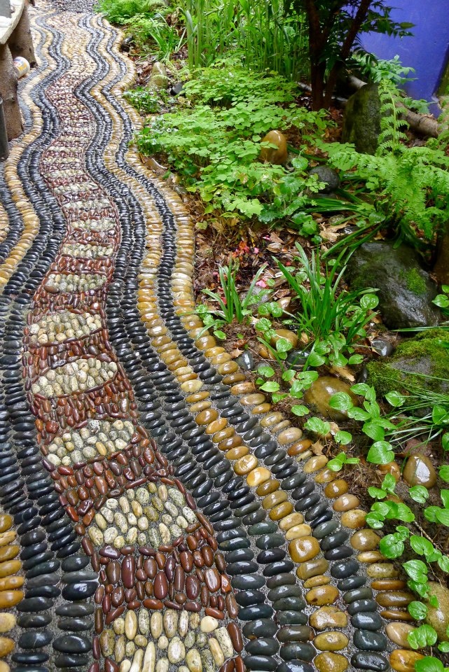 A bright pebble pathway in burgundy, yellow, black and neutrals with catchy patterns looks boho and relaxed