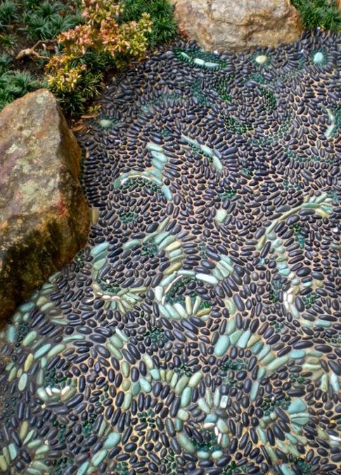 a pebble garden path done with patterns in mint green is a beautiful idea with a touch of color