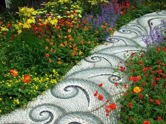 a white, grey and ombre green pebble path with an eye-catchy pattern is a bold idea for a bright garden